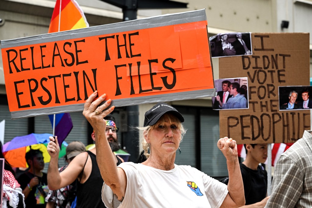 Protestors hold signs demanding the release of Jeffrey Epstein files.