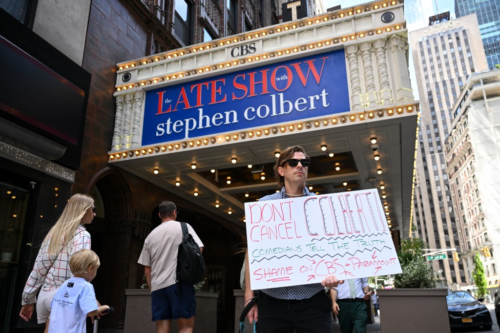 Protestor holding sign supporting Stephen Colbert outside the Ed Sullivan Theater.