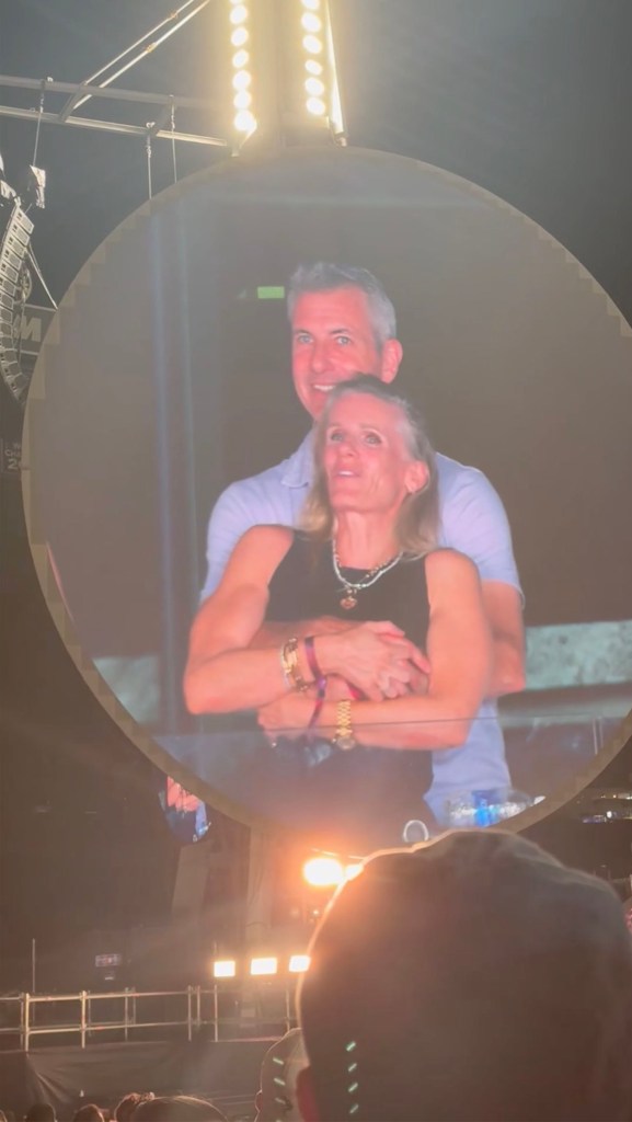 Photo of a couple embracing on a jumbotron at a Coldplay concert.